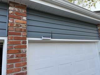 Solar-powered Meshtastic node hanging on house siding for testing